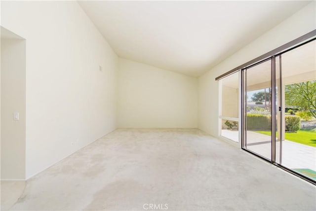 empty room with carpet flooring and lofted ceiling