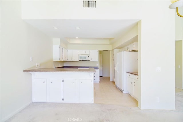 kitchen featuring white cabinetry, kitchen peninsula, and white appliances