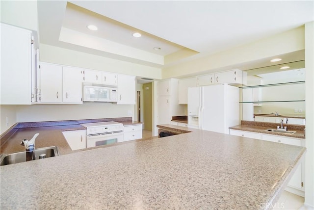 kitchen with white cabinetry, white appliances, and a tray ceiling