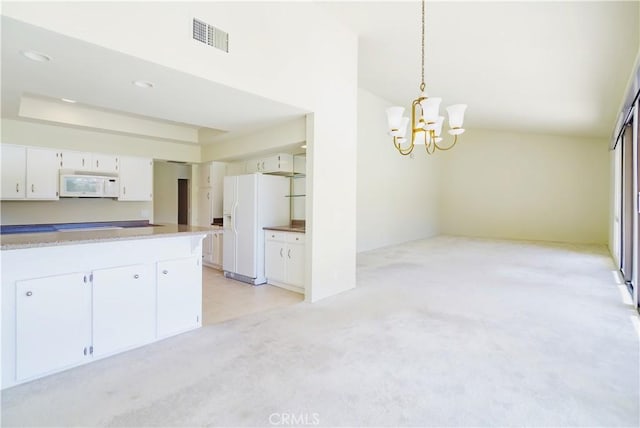 kitchen featuring white appliances, white cabinets, decorative light fixtures, a notable chandelier, and light colored carpet