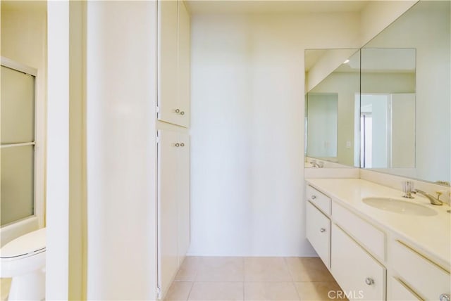 full bathroom featuring toilet, vanity, tile patterned floors, and combined bath / shower with glass door