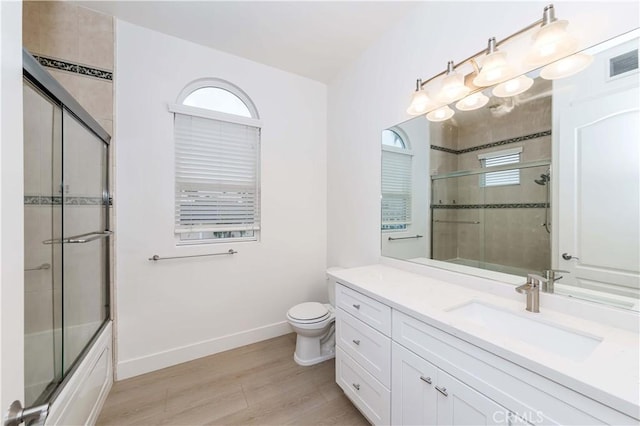 full bathroom featuring enclosed tub / shower combo, toilet, wood-type flooring, and vanity