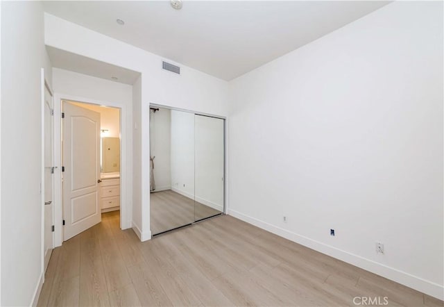 unfurnished bedroom featuring light hardwood / wood-style floors and a closet