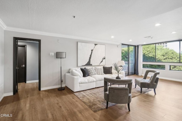 living room with floor to ceiling windows, hardwood / wood-style floors, and ornamental molding