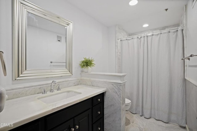 bathroom featuring a shower with shower curtain, vanity, and toilet