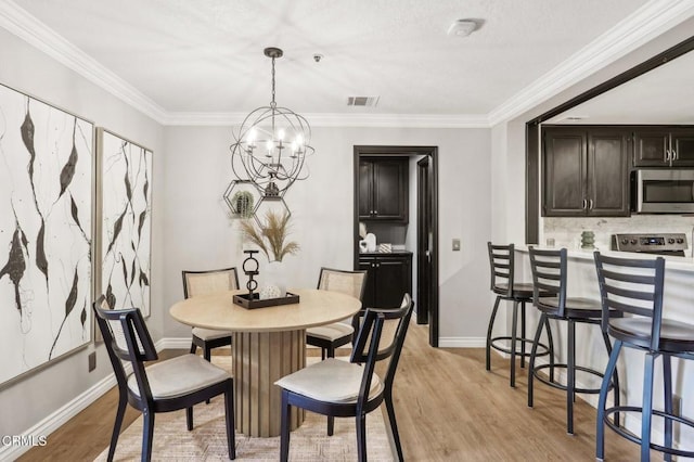 dining space featuring a notable chandelier, light hardwood / wood-style floors, and crown molding