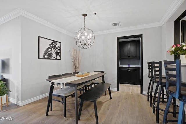 dining room featuring light hardwood / wood-style floors, an inviting chandelier, and crown molding