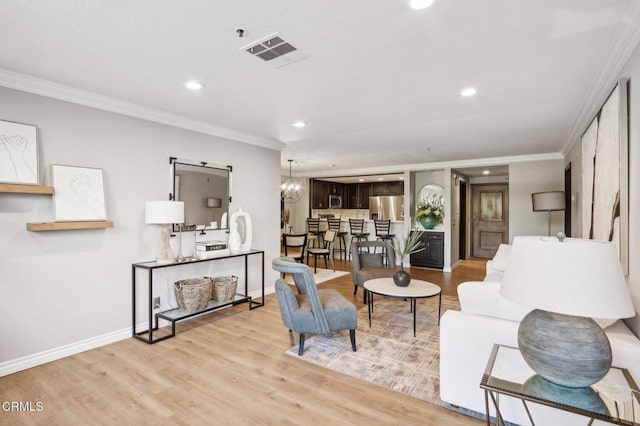 living room featuring crown molding, light hardwood / wood-style floors, and a notable chandelier