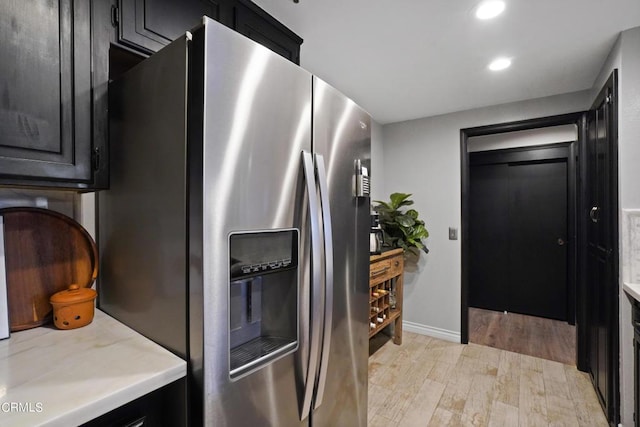 kitchen featuring stainless steel fridge with ice dispenser and light hardwood / wood-style flooring