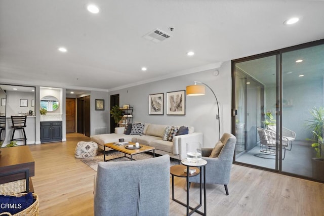 living room with light hardwood / wood-style flooring and ornamental molding