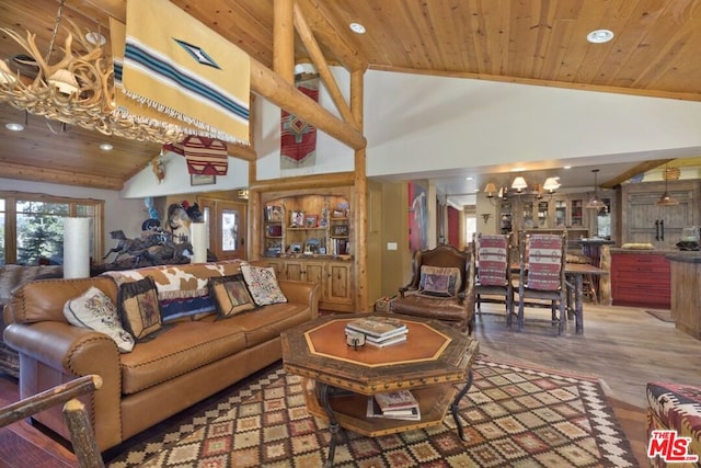 living room with hardwood / wood-style flooring, high vaulted ceiling, and a chandelier