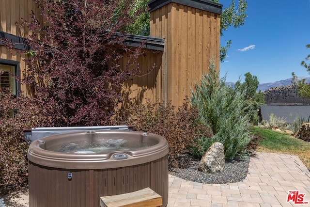 exterior space featuring a mountain view and a hot tub