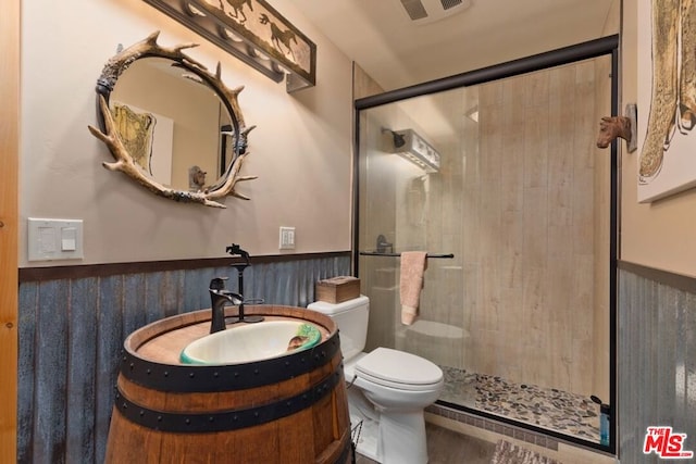 bathroom featuring vanity, toilet, and a shower with door