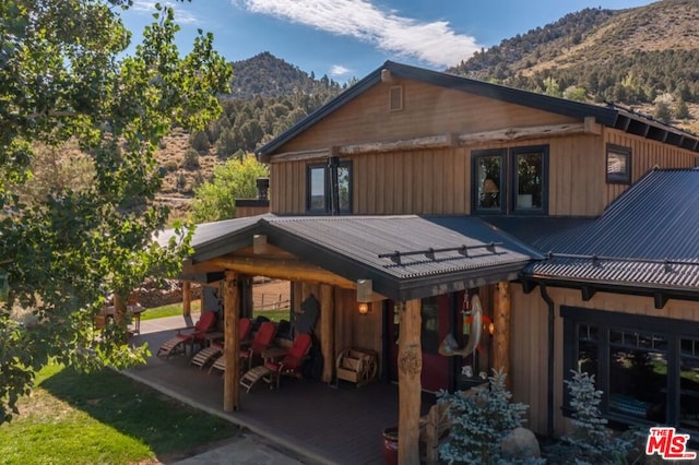 view of property exterior featuring a mountain view, french doors, and a patio area