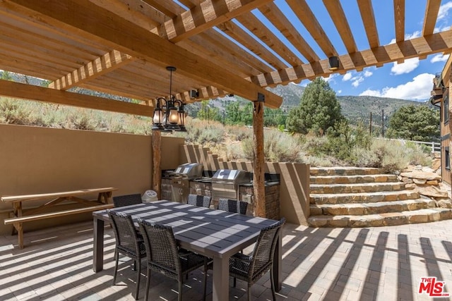 view of patio featuring a pergola, area for grilling, a grill, and a mountain view