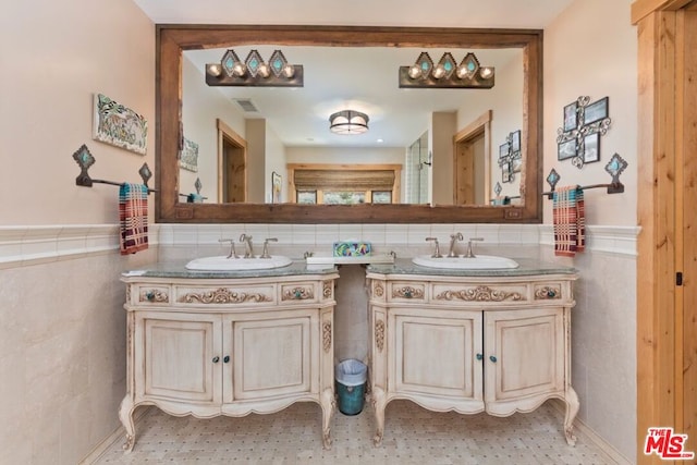 bathroom featuring vanity and tile walls