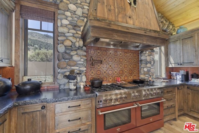 kitchen with wooden ceiling, light hardwood / wood-style flooring, lofted ceiling, range with two ovens, and custom range hood