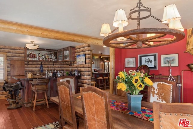 dining area with rustic walls, wood-type flooring, indoor bar, and a notable chandelier