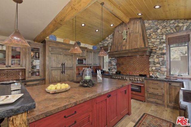 kitchen featuring custom range hood, stainless steel appliances, pendant lighting, vaulted ceiling with beams, and light hardwood / wood-style floors