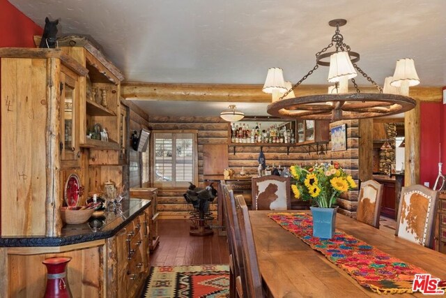 dining area featuring log walls, bar area, and dark wood-type flooring