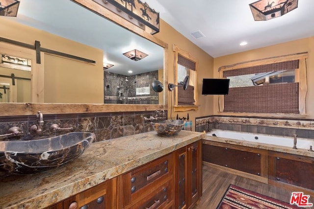 bathroom with plus walk in shower, vanity, and hardwood / wood-style flooring