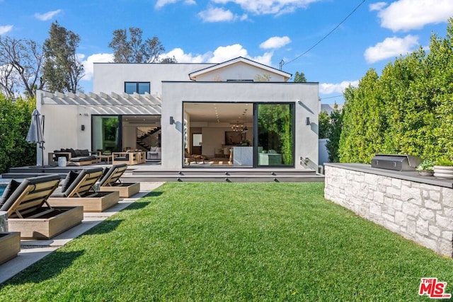 rear view of house with an outdoor kitchen, a lawn, and a pergola