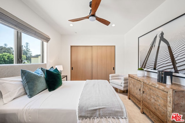 carpeted bedroom featuring ceiling fan and a closet