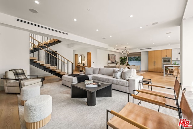 living room with a notable chandelier and light wood-type flooring