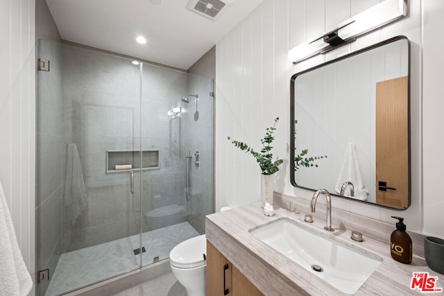 bathroom featuring vanity, toilet, and an enclosed shower