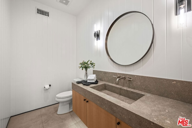 bathroom featuring vanity, tile patterned floors, and toilet