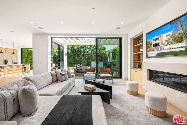 living room with expansive windows, built in features, and a fireplace