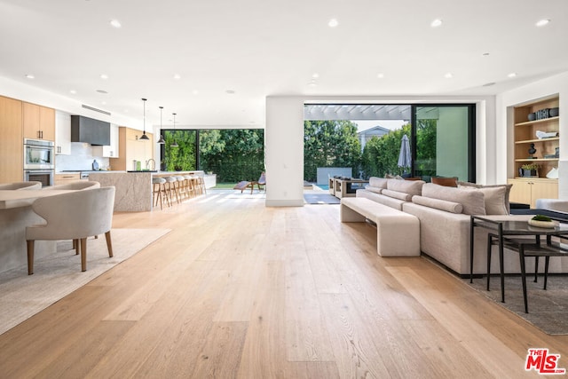 living room featuring light hardwood / wood-style floors and built in shelves