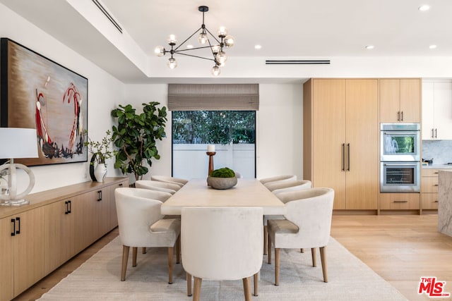 dining space featuring an inviting chandelier and light hardwood / wood-style floors