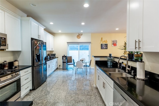 kitchen featuring white cabinets, appliances with stainless steel finishes, and sink