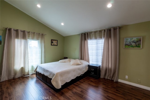 bedroom with multiple windows, dark hardwood / wood-style flooring, and lofted ceiling