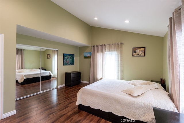 bedroom featuring a closet, dark wood-type flooring, and vaulted ceiling