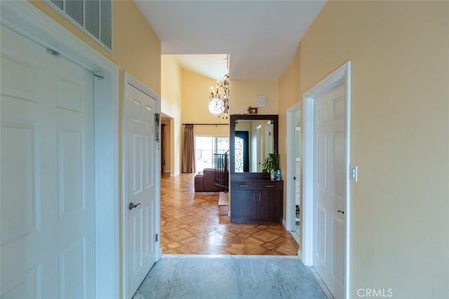 hallway featuring light parquet floors and an inviting chandelier