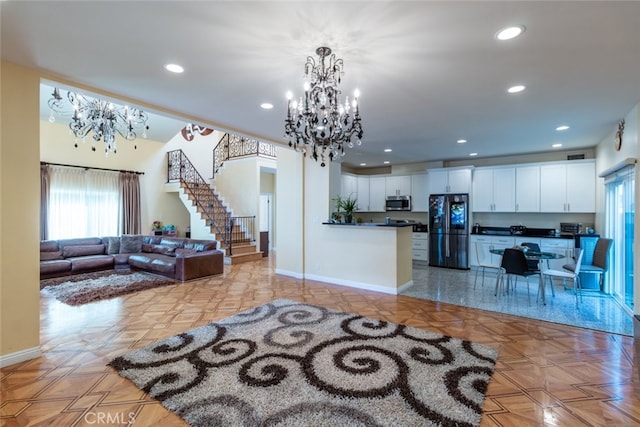 kitchen featuring light parquet floors, a chandelier, decorative light fixtures, black refrigerator, and white cabinets