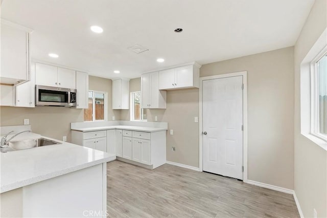 kitchen featuring a wealth of natural light, sink, and white cabinets