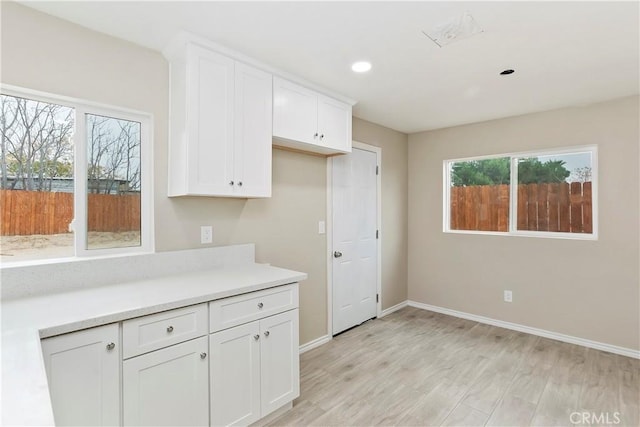 kitchen featuring light hardwood / wood-style floors, white cabinetry, and plenty of natural light