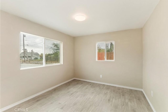 spare room featuring a healthy amount of sunlight and light wood-type flooring