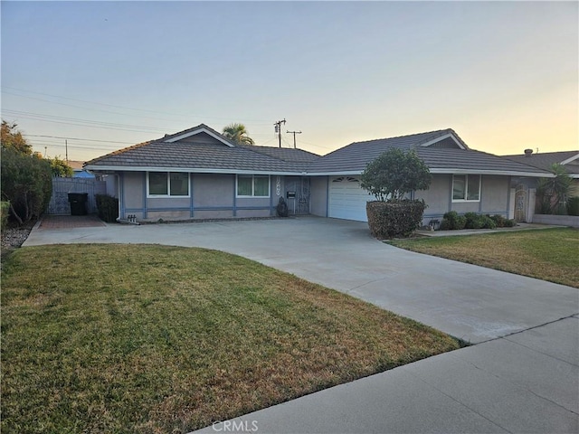 ranch-style home with a garage and a yard