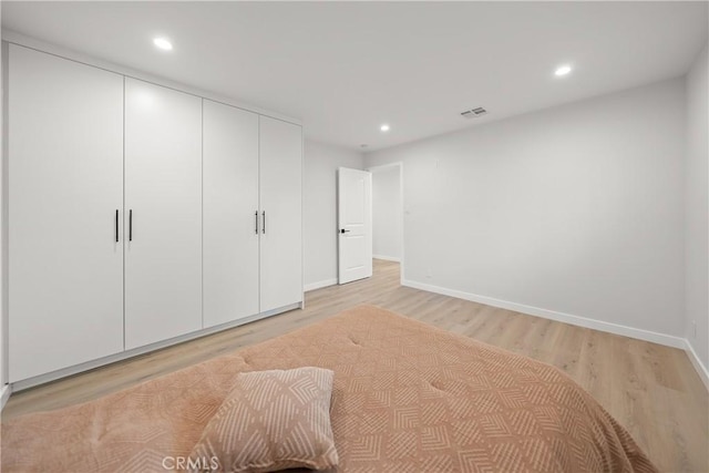 unfurnished bedroom featuring a closet and light wood-type flooring