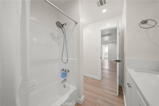 bathroom with washtub / shower combination, hardwood / wood-style floors, and vanity