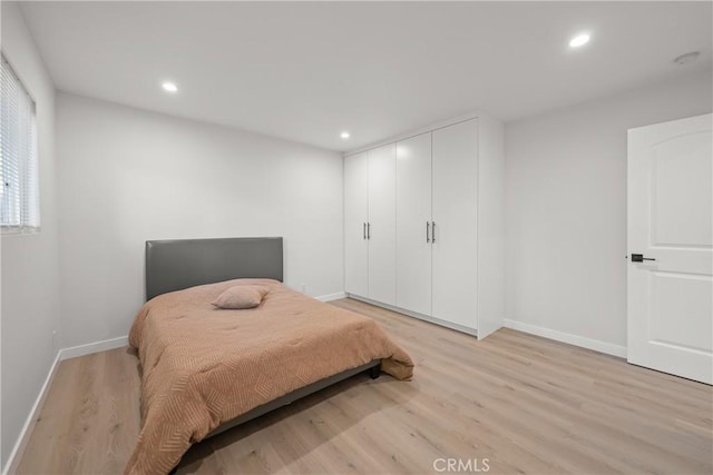 bedroom with light wood-type flooring and a closet