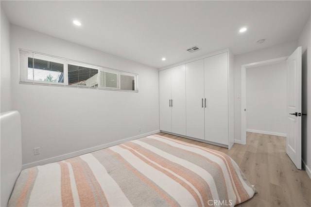 unfurnished bedroom featuring a closet and light wood-type flooring