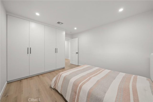 bedroom with a closet and light hardwood / wood-style floors