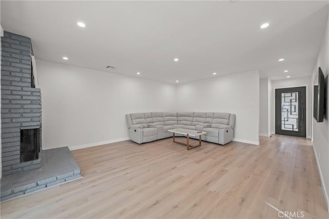 living room featuring a fireplace and light hardwood / wood-style flooring