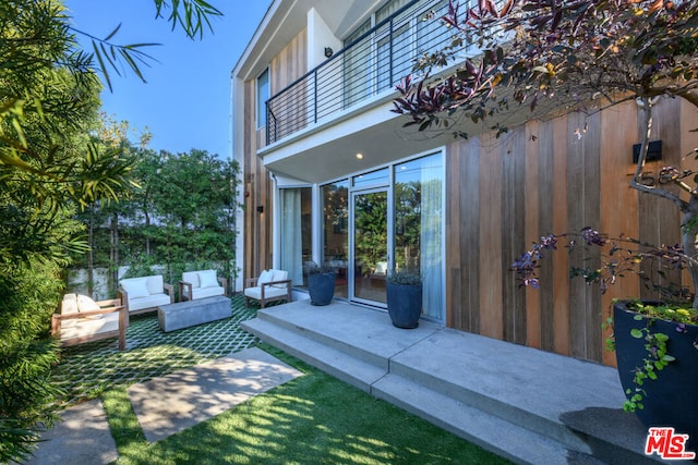 view of patio with an outdoor living space and a balcony