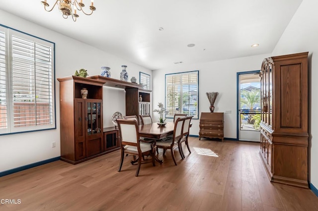 dining space with wood-type flooring and a chandelier